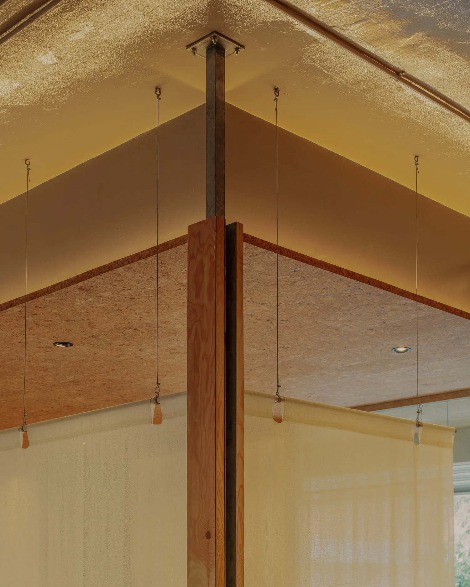 Modern interior design featuring wooden accents, concrete walls, and steel structural elements.