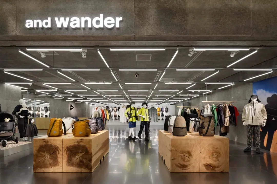 A retail shop interior with concrete walls and floors, showcasing apparel and accessories.