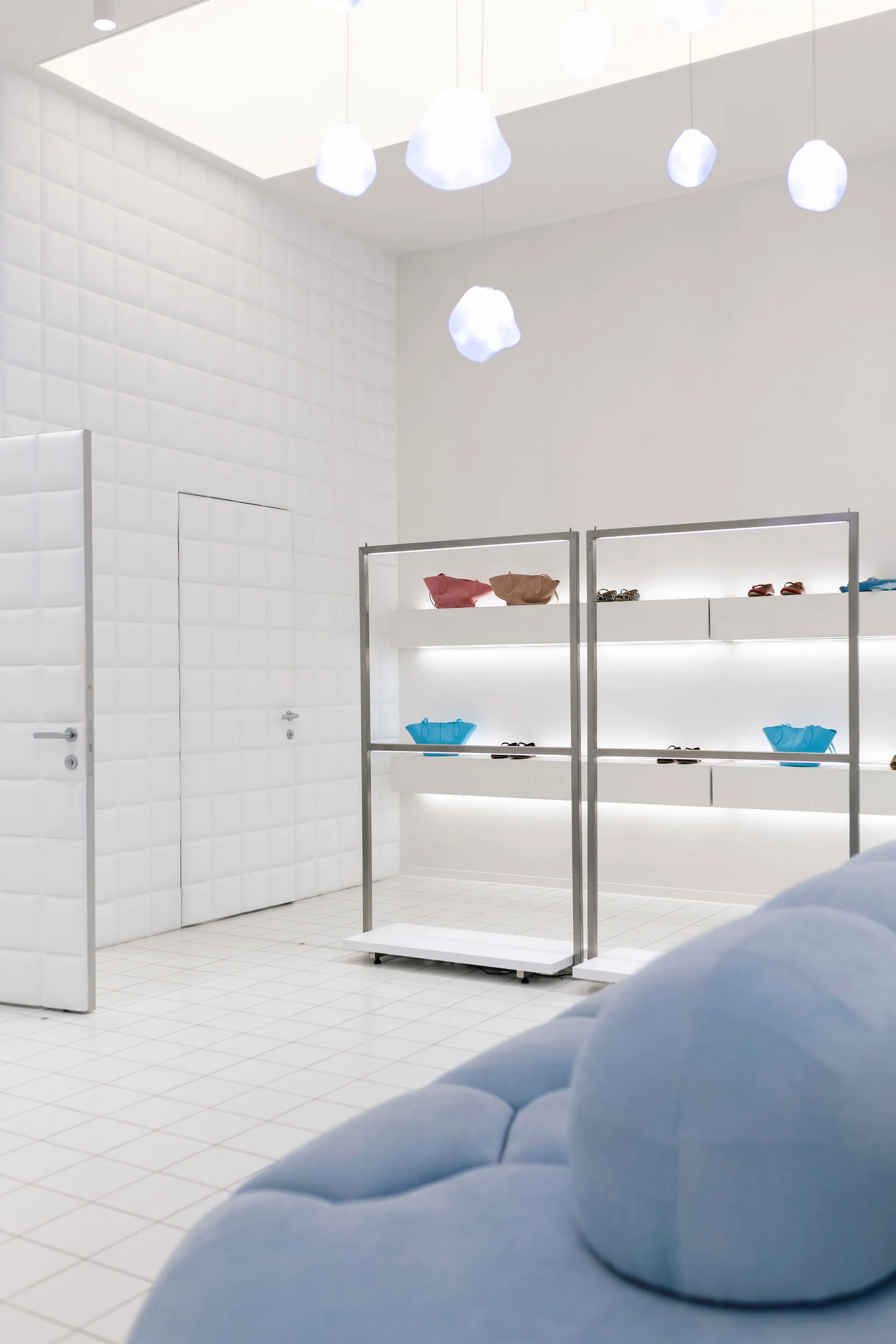 A minimalist retail space featuring metal, glass, and fabric elements.