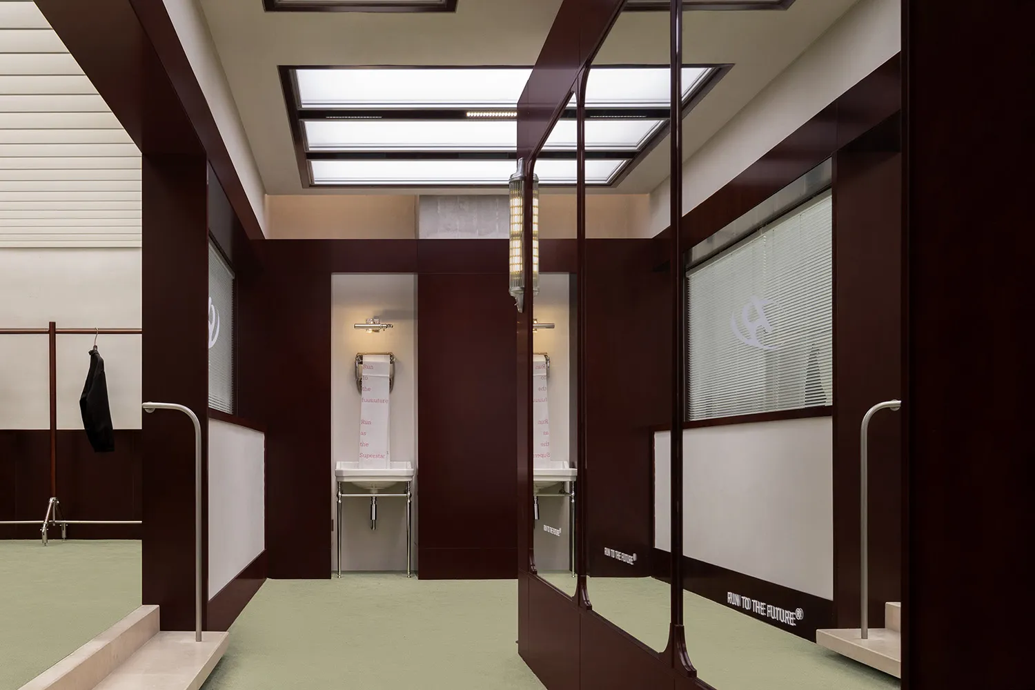 A modern gym interior showing walls with metal fittings and reflections on the floor.