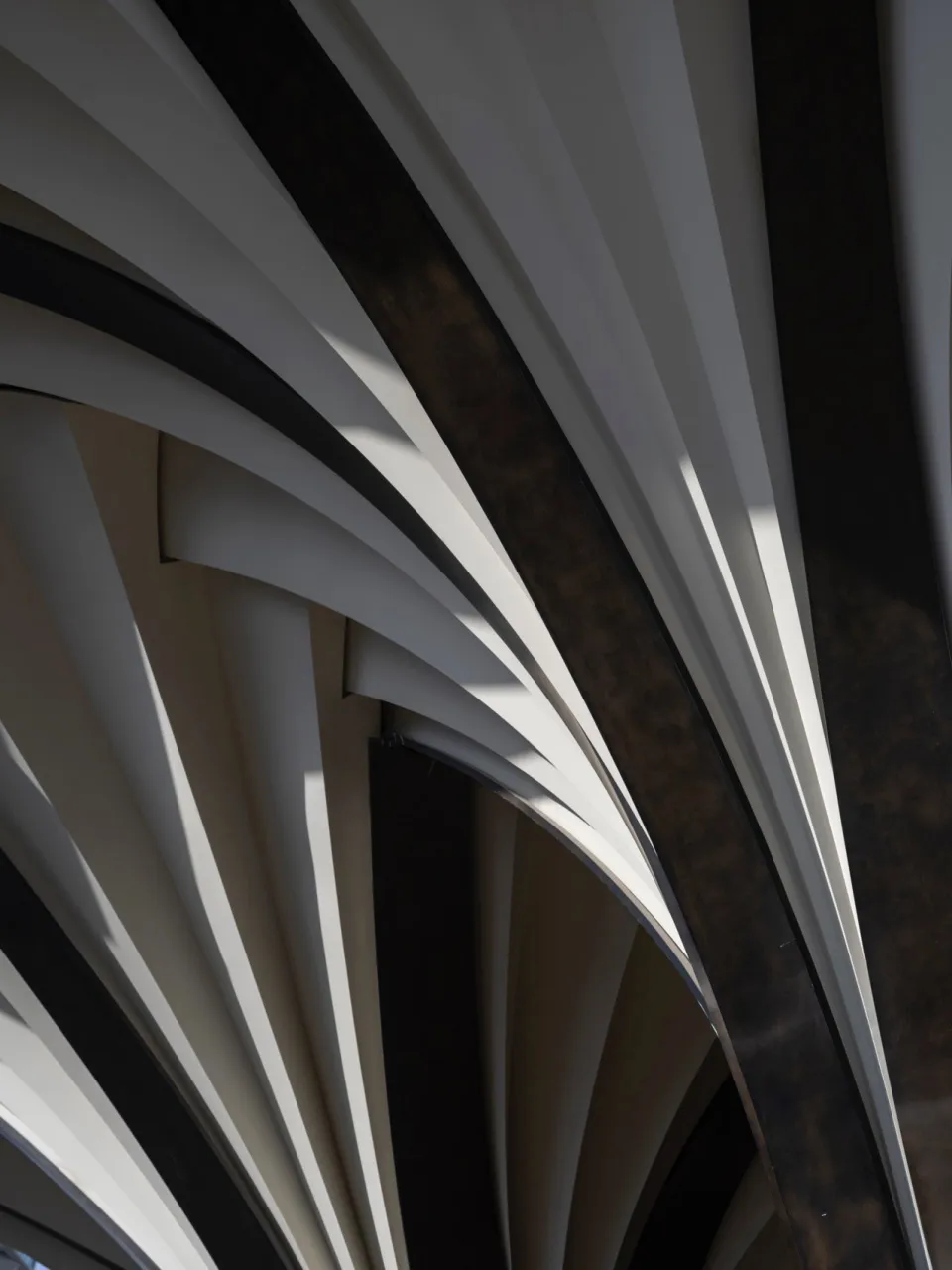 Modern architectural detail with metallic, glass, and concrete materials.