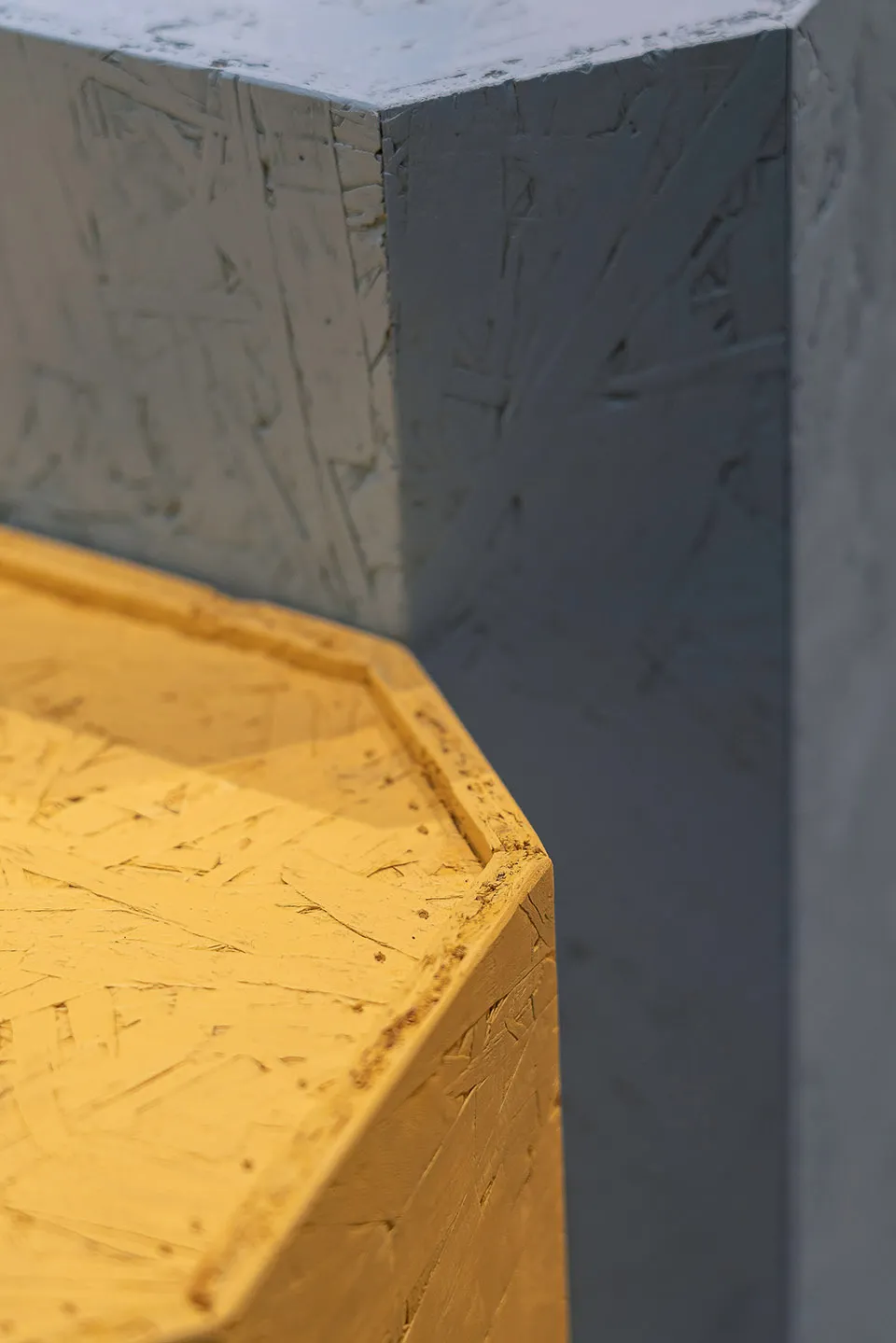 Close-up of a modern interior design featuring yellow-painted concrete walls.