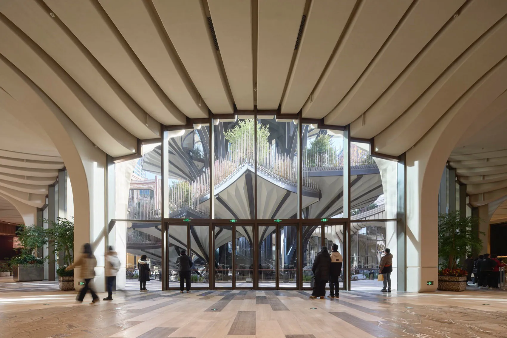 Modern lobby with glass walls and arched columns.