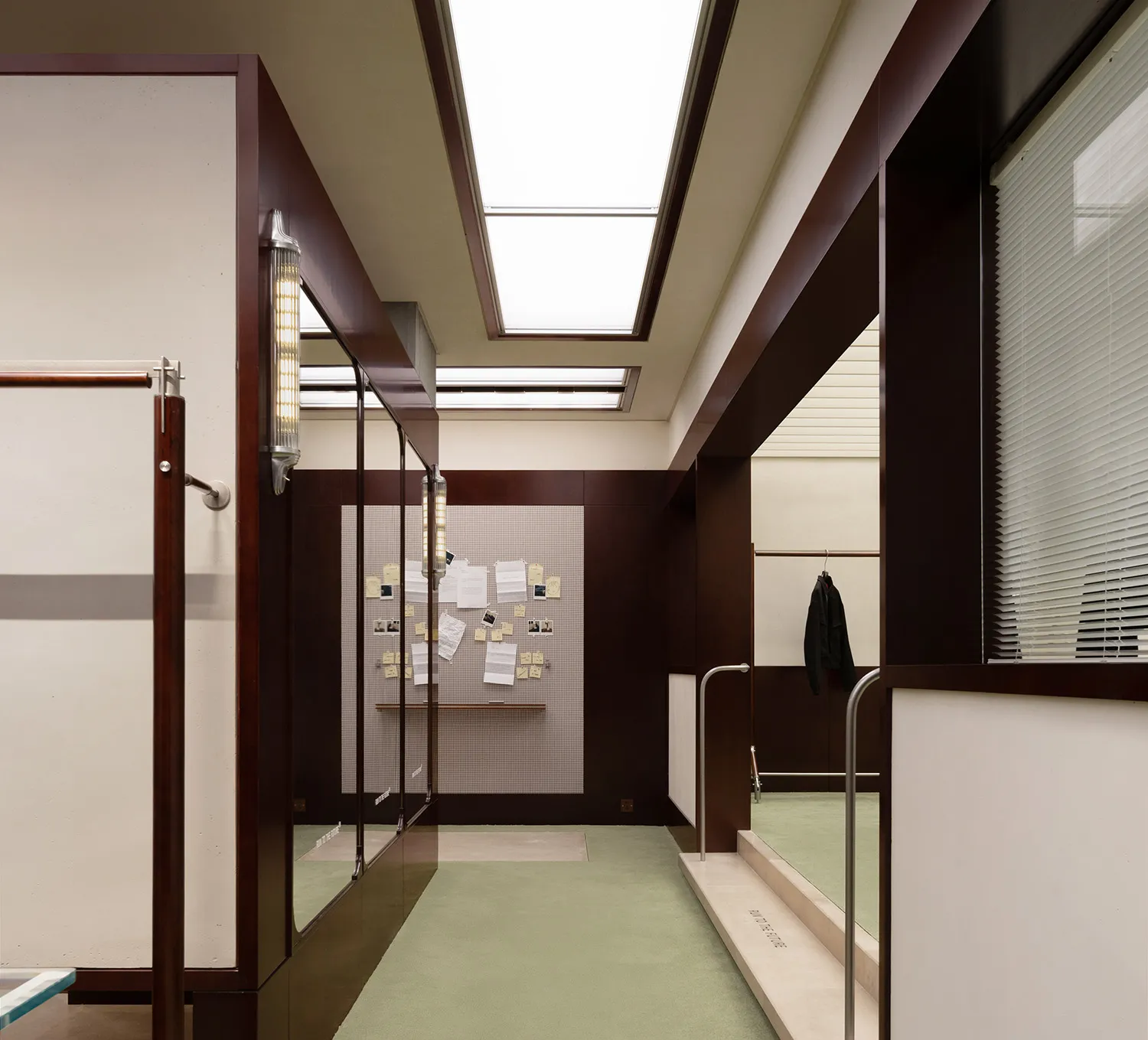 一間辦公空間，具備現代建築元素，如玻璃門、木質裝飾與混凝土地板。