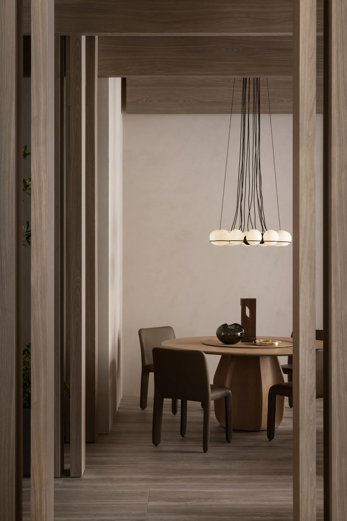 A modern dining room featuring a wooden table with a unique chandelier and chairs.