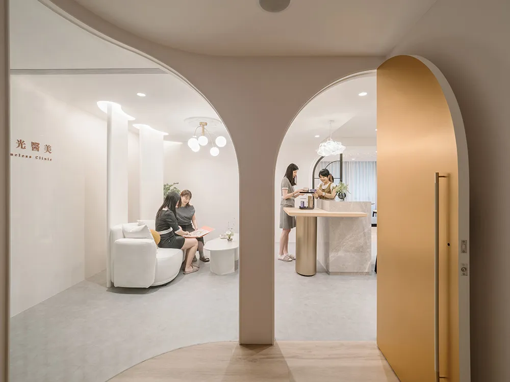 People in a spa clinic with white marble decor, modern furniture, and minimalist design.
