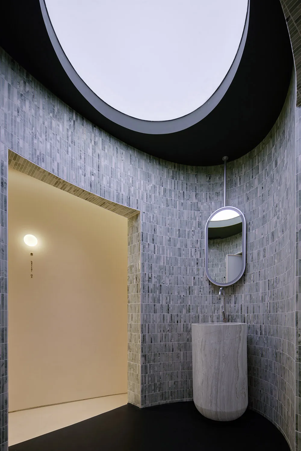 Modern bathroom design featuring marble tiles, sleek lines, and a curved ceiling with a circular skylight.