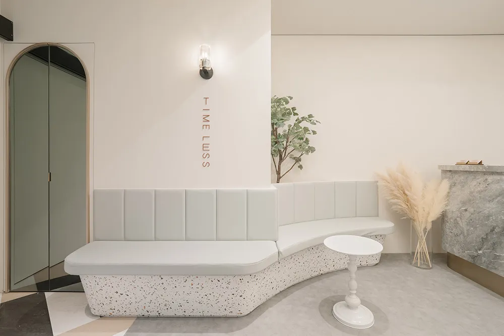 A modern lobby with a curved, terrazzo-finished bench and minimalist design elements.