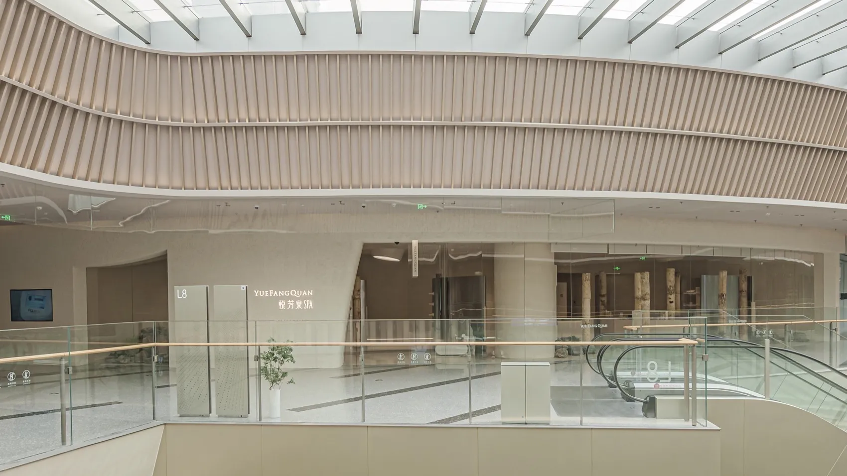 現代購物中心擴建區的室內視角,展現玻璃、混凝土與木質建築元素。