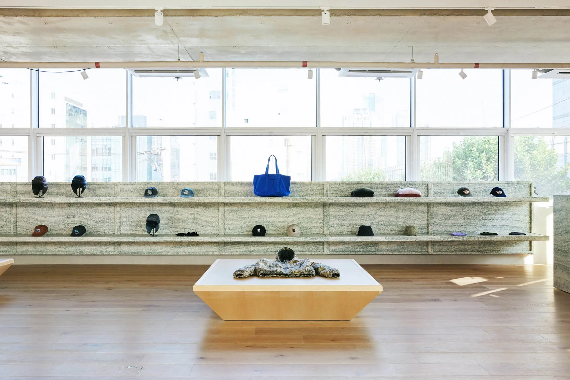 Retail store interior with granite countertop displaying various baseball caps.