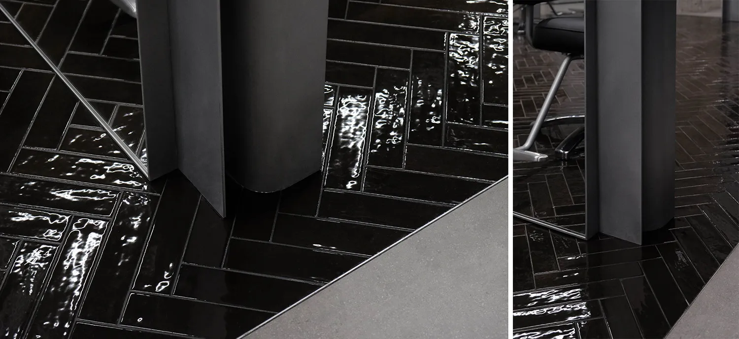 A modern floor with black tiles in a herringbone pattern.