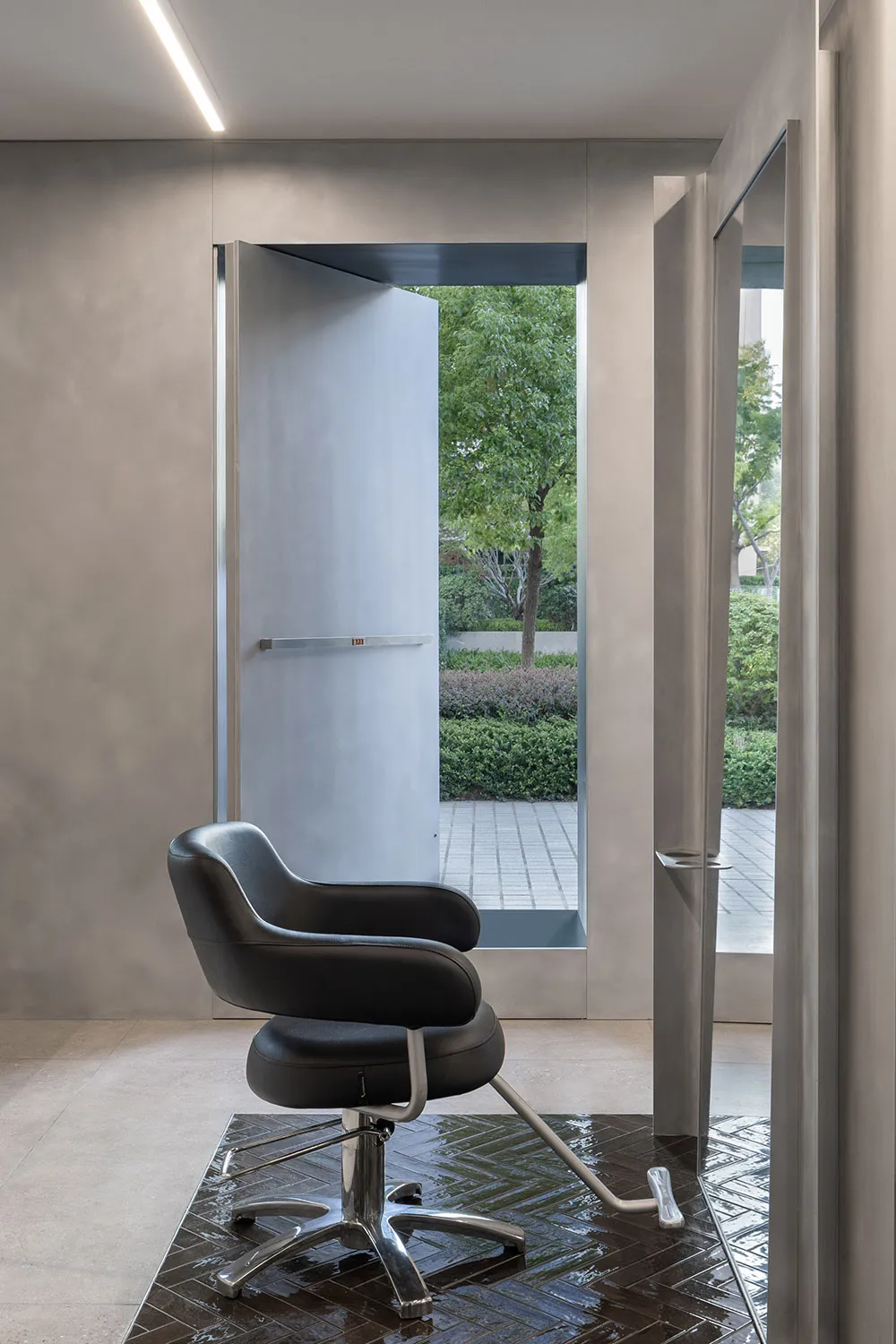 A minimalist design of a hair studio featuring a gray-scaled color palette and metal finishes.
