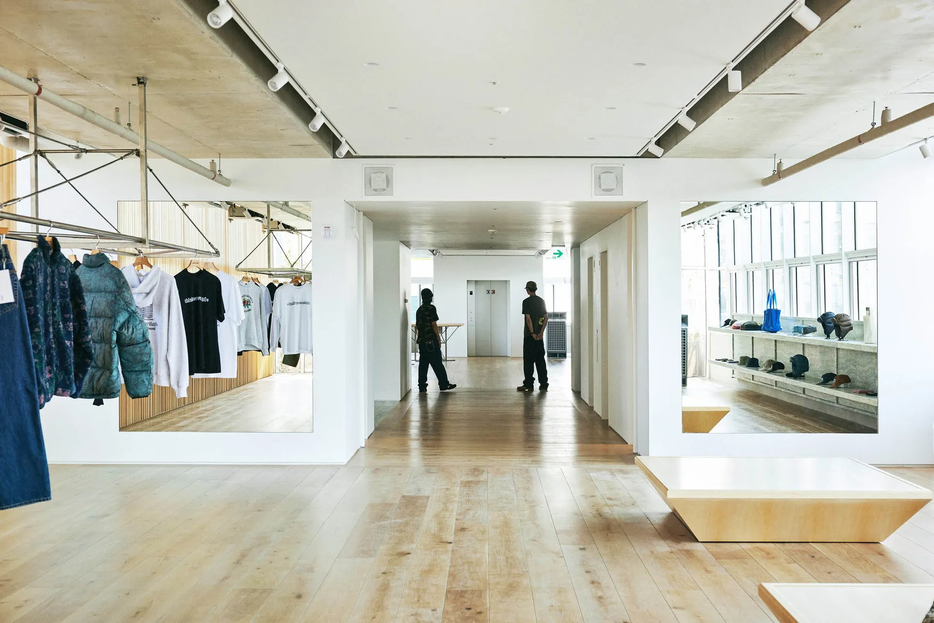 A modern retail shop featuring industrial concrete design elements and wooden flooring.