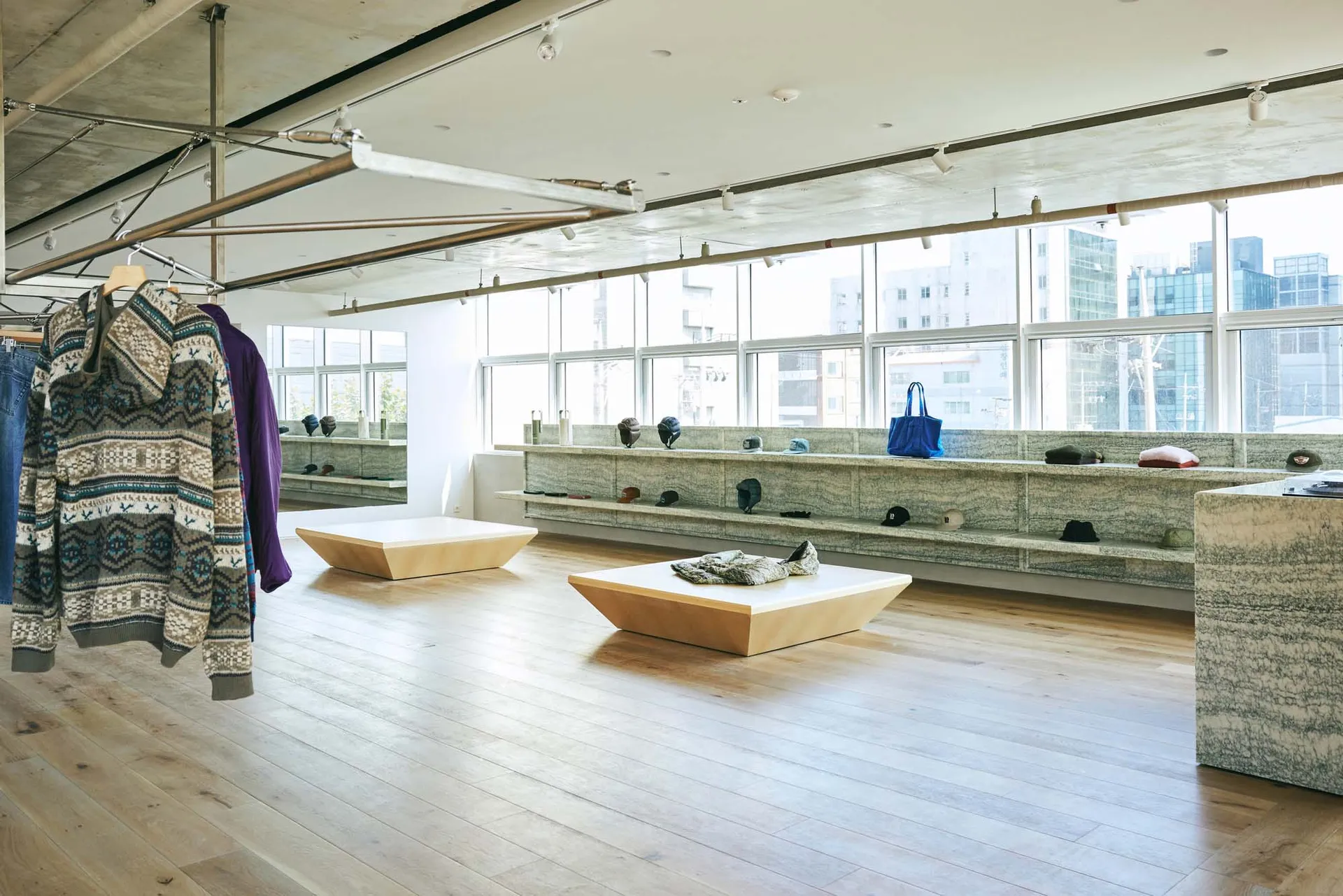 Interior design of a modern clothing shop featuring wooden furniture, showcasing stylish clothing displays.
