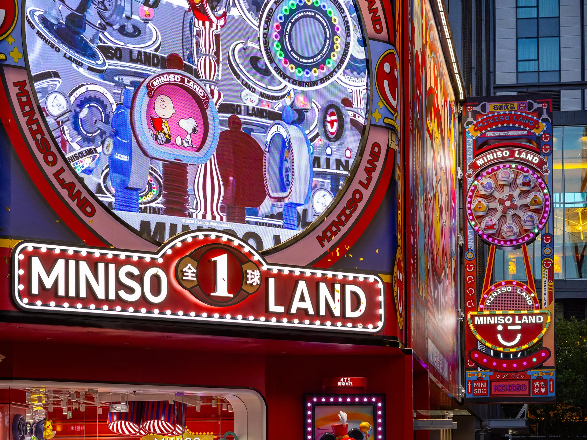 Colorful Miniso Land storefront with digital-printed signage and light-reflecting panels.