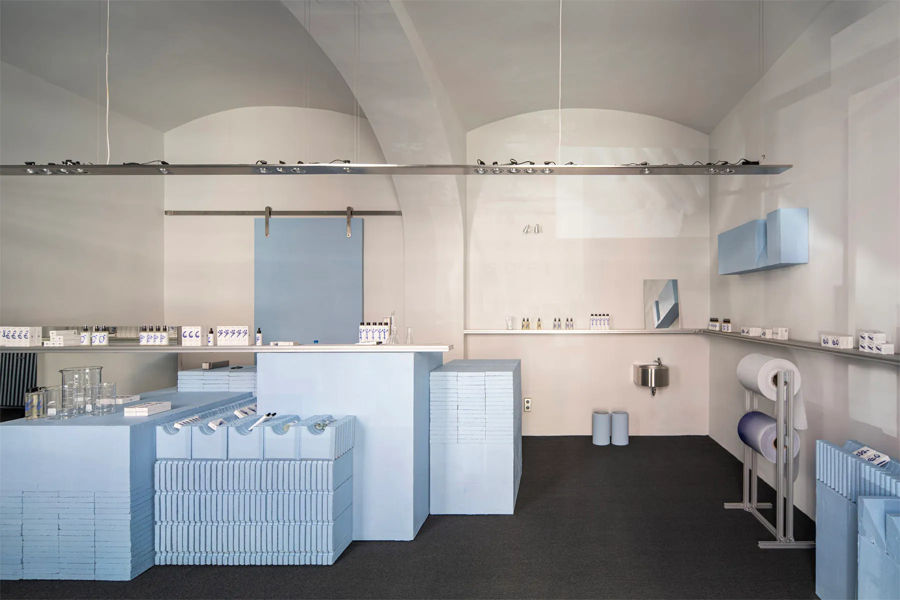 A retail storefront with blue-painted walls and concrete flooring.