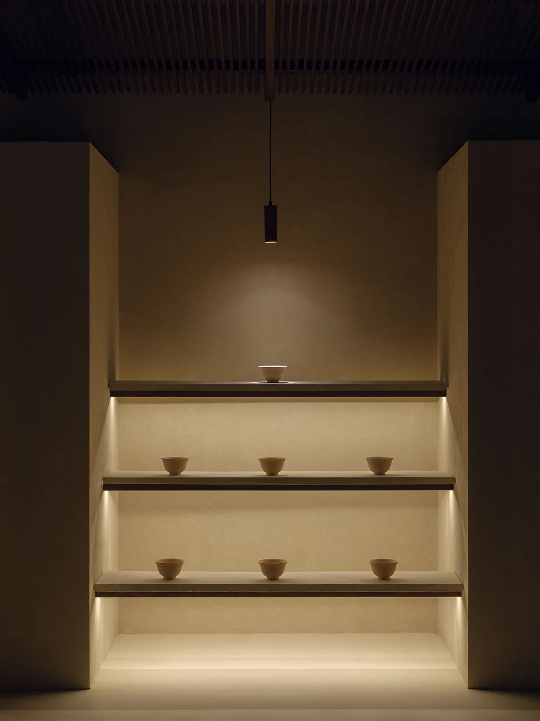 A minimalist interior featuring concrete elements with strategic lighting.
