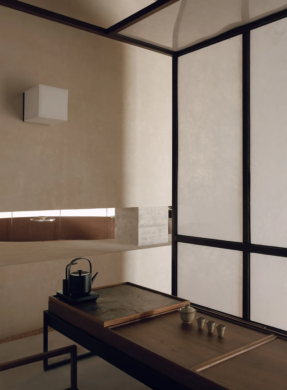 A minimalist modern tea room with wooden elements and a tea setup on a table.