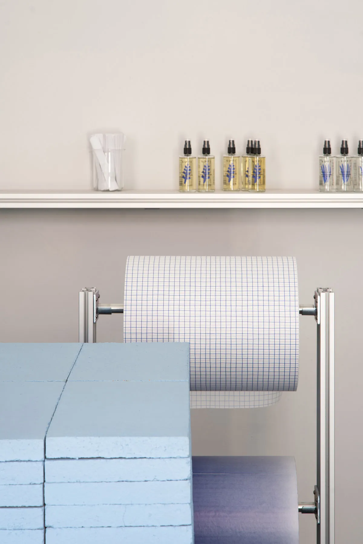 Spa interior with paper rolls on a rack, spa bottles, and stacked blocks of spa materials.