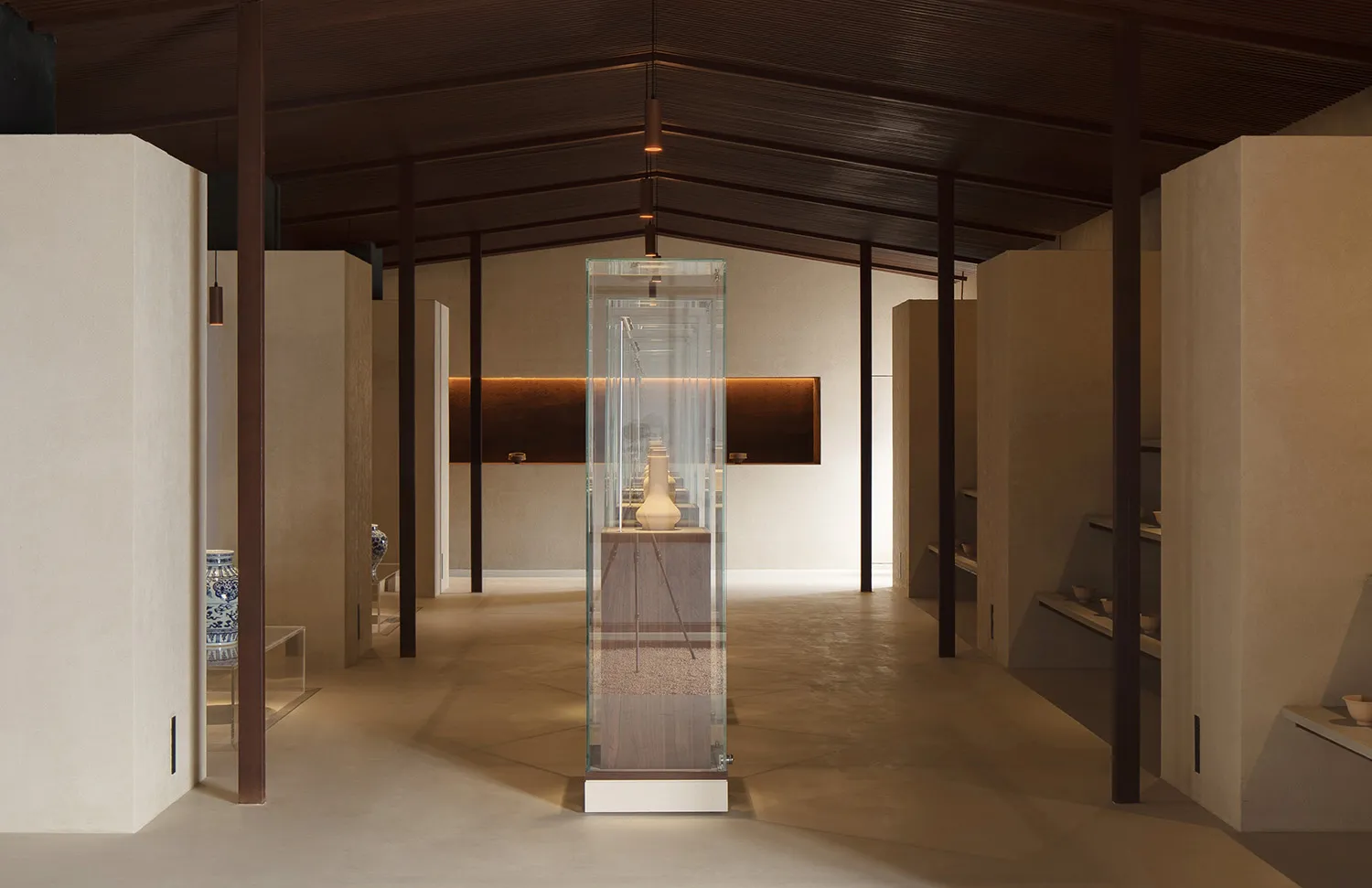 Modern museum exhibition featuring a glass case displaying a vase