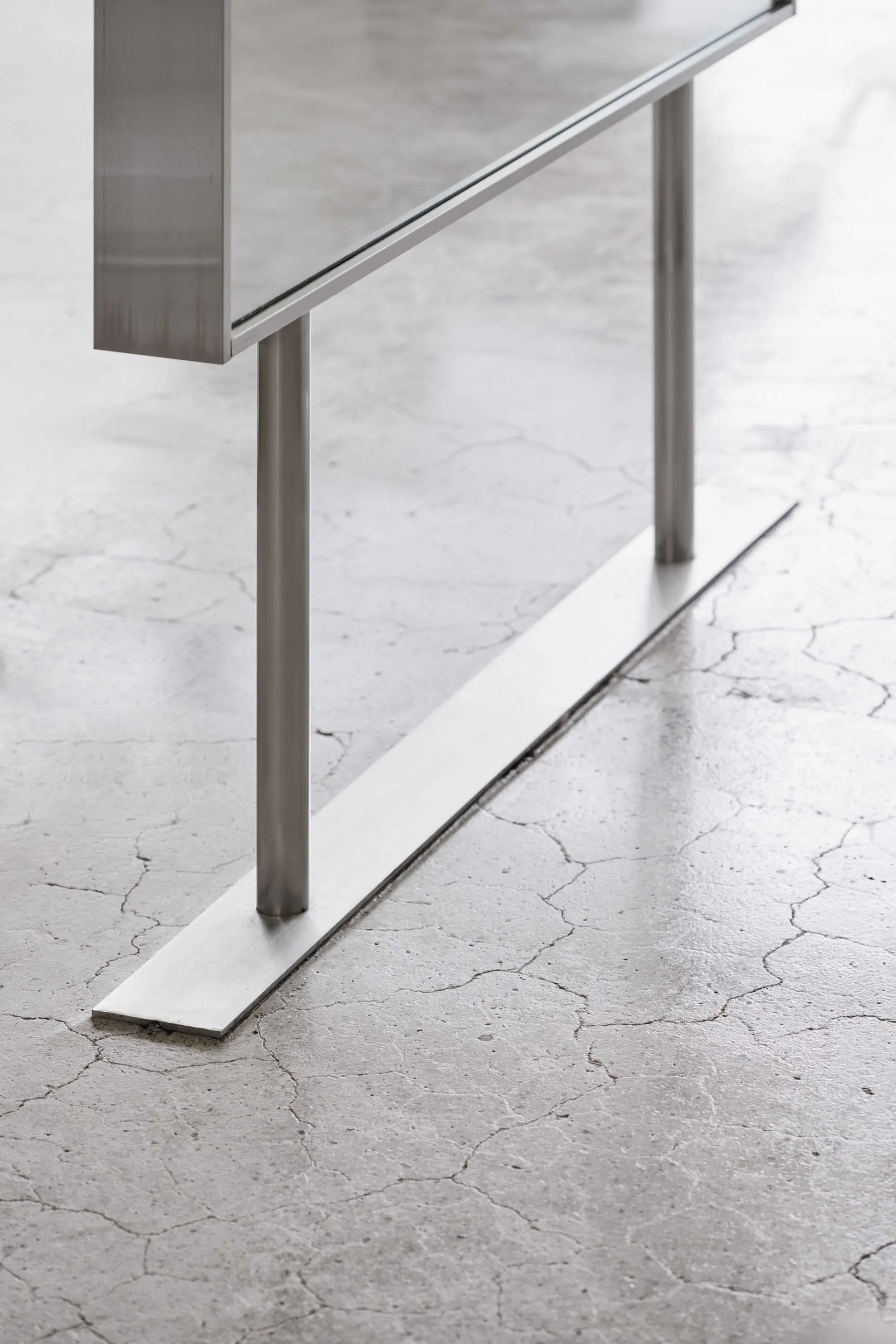 A minimalist design featuring a concrete floor, metal legs, and industrial style.