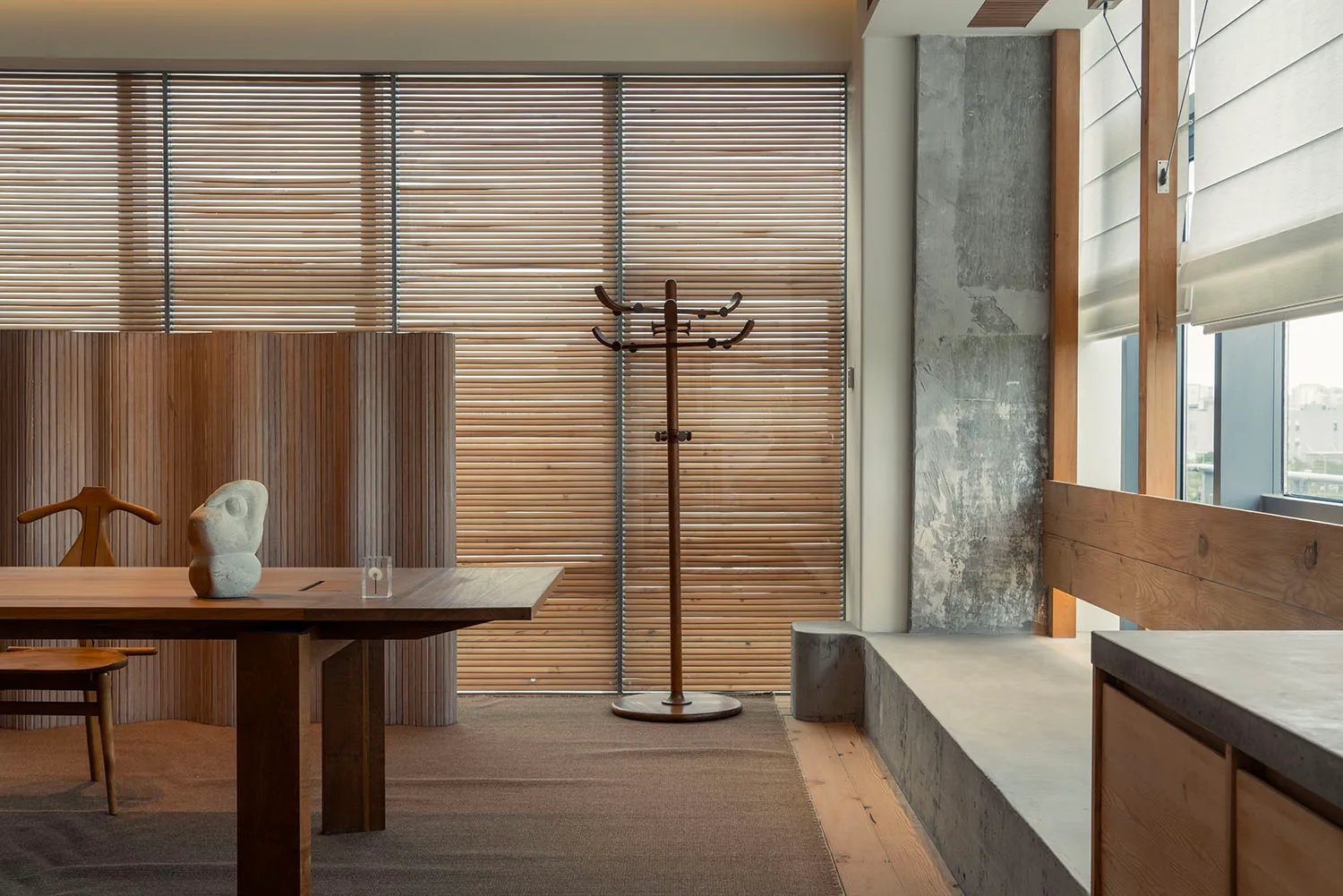 Modern minimalist living room featuring wood furniture and concrete accents.
