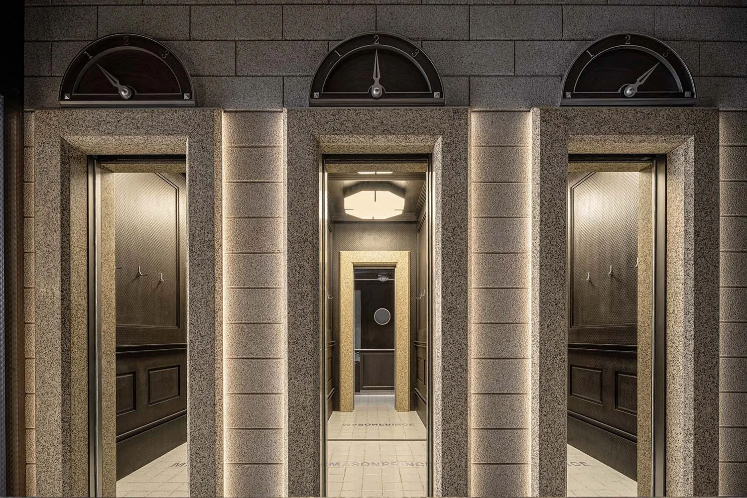 Granite columns with elevator doors in an interior setting.