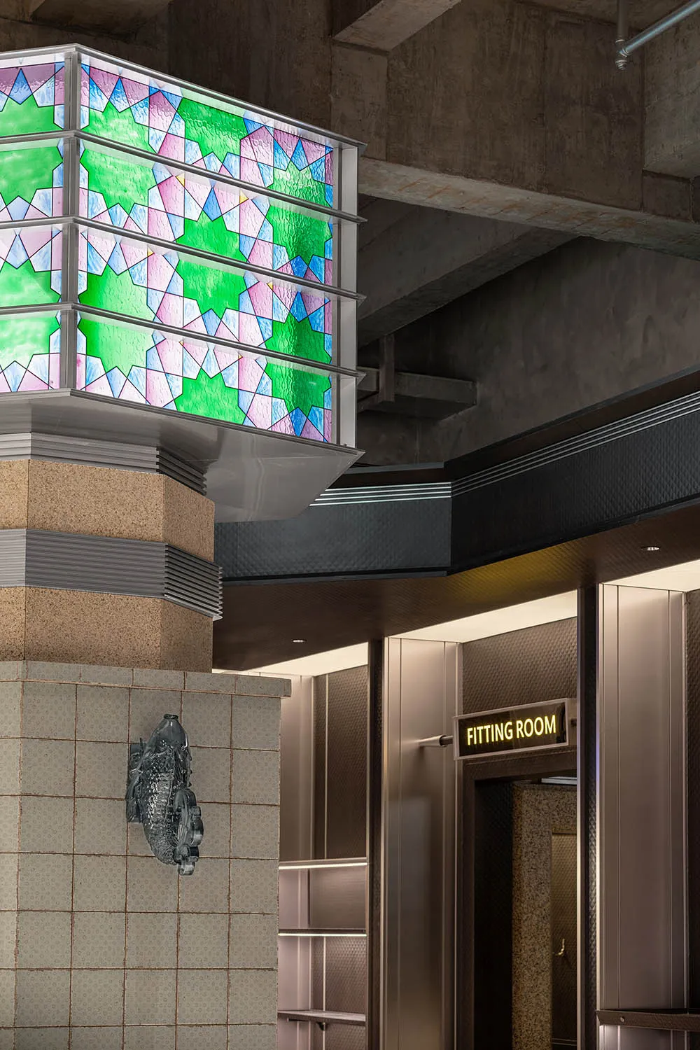 A modern, industrial interior design featuring a glass panel with geometric patterns.