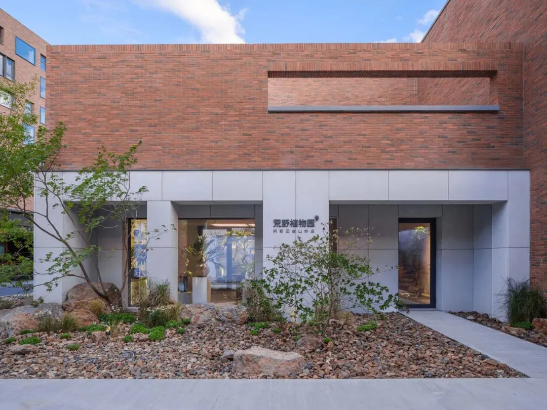 Modern building exterior with brick facade and rock garden