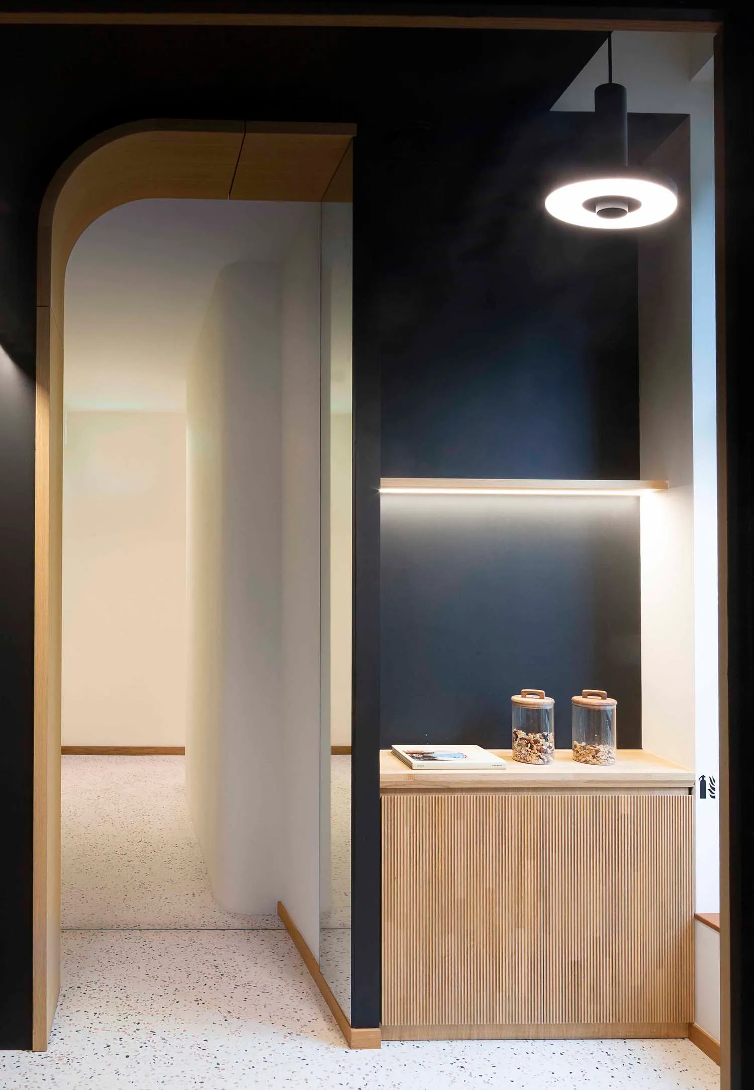 A minimalist entryway with solid wood elements and soft ambient lighting.