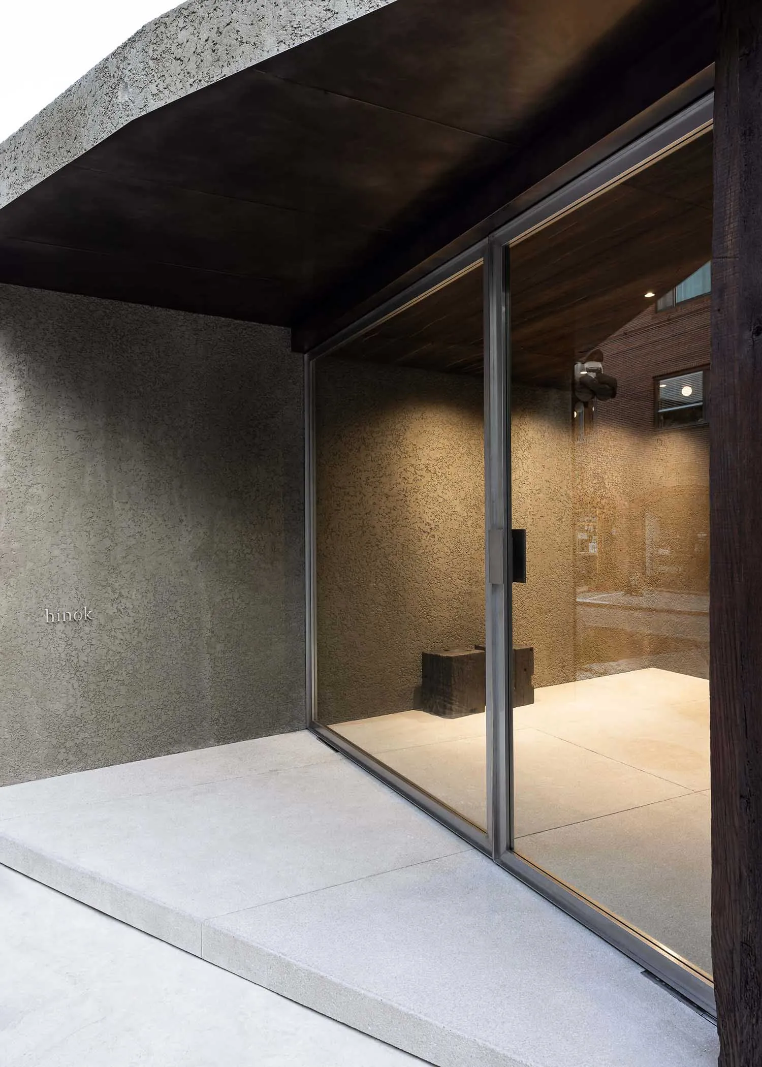 Modern retail store entrance featuring large glass doors and a concrete ground.
