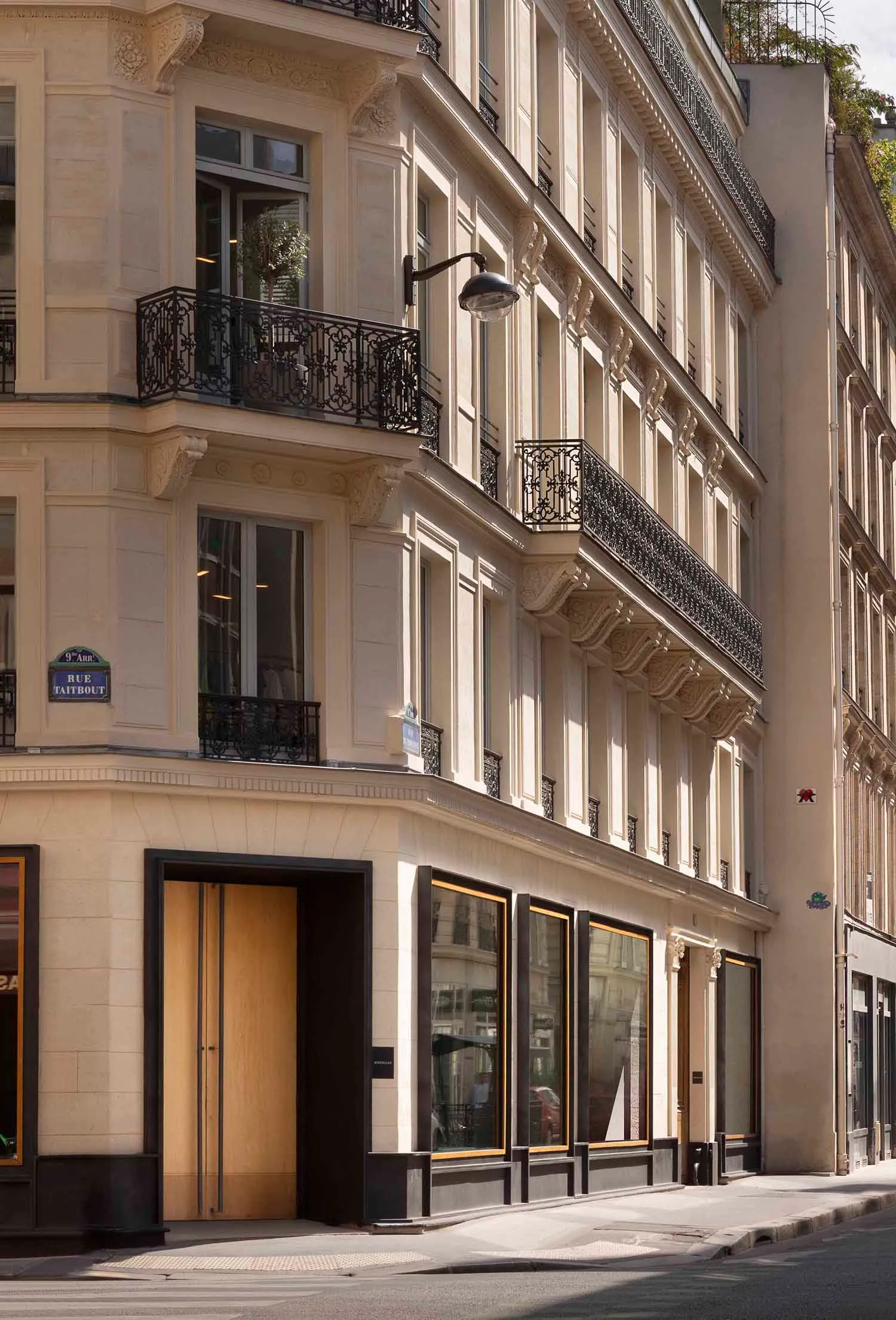 The facade of a stone building with metal railings on a Parisian street.