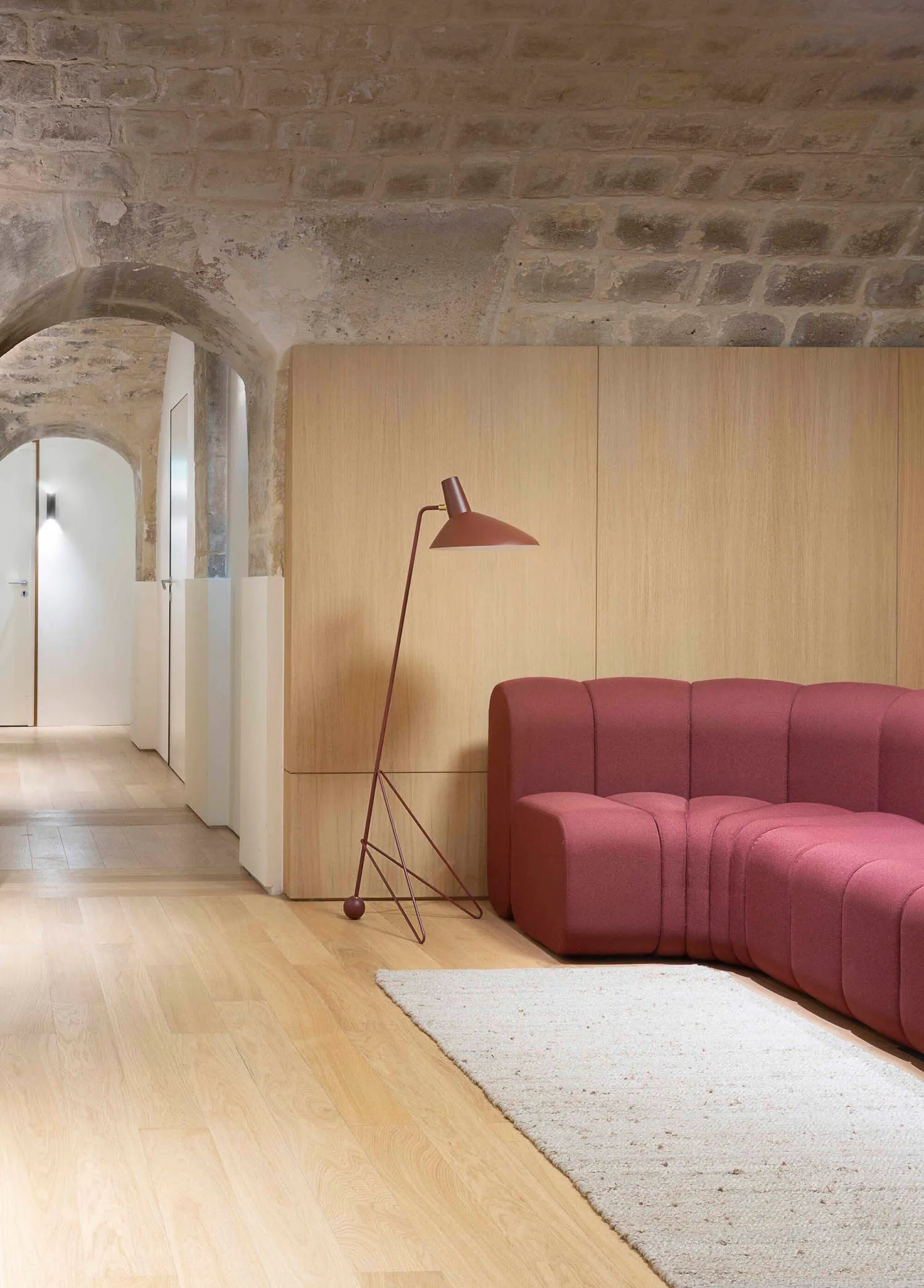 Contemporary living room featuring wooden flooring and a pink fabric sofa with a red floor lamp.