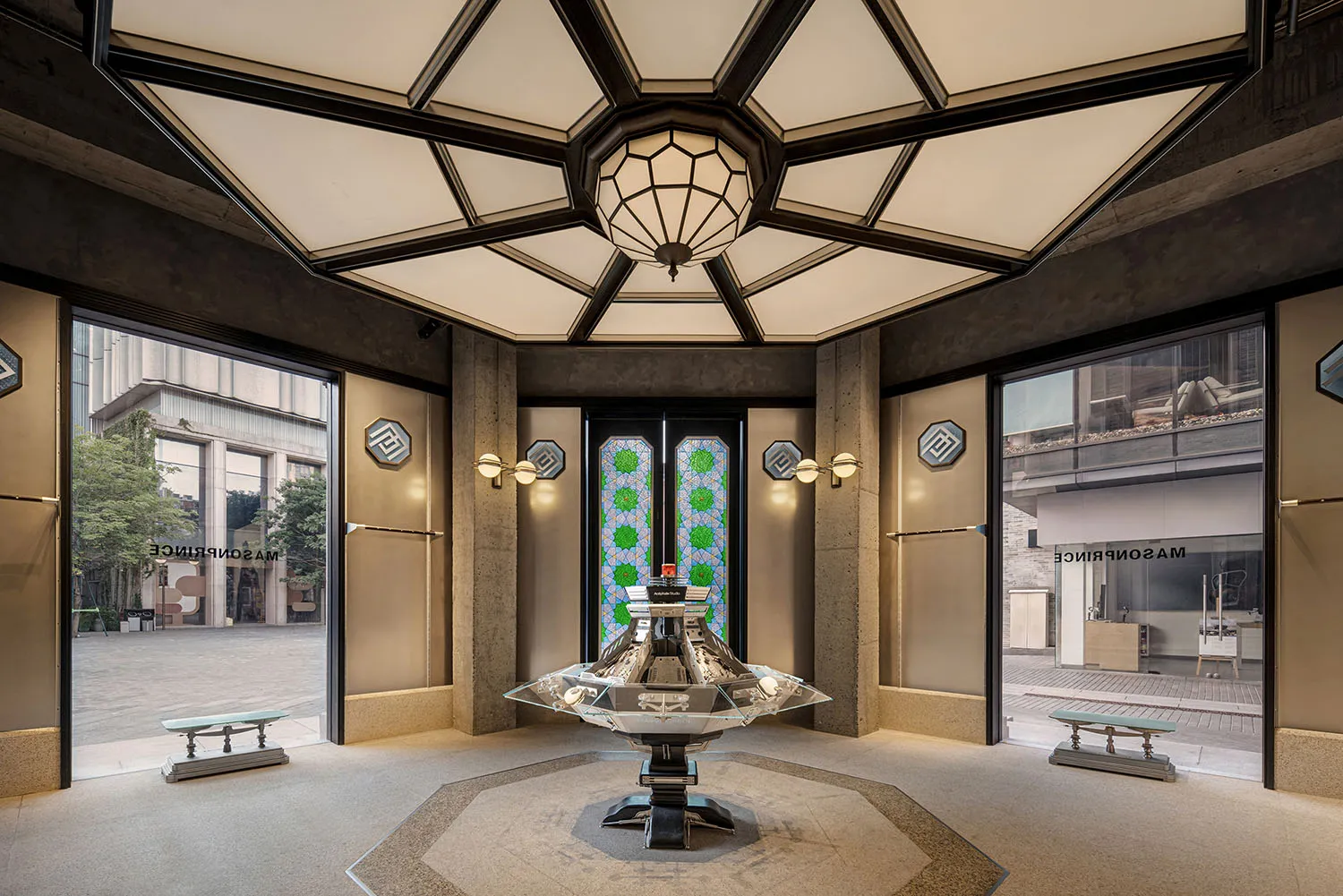 A futuristic lobby interior with a concrete floor, geometric ceiling, and a central glass sculpture.