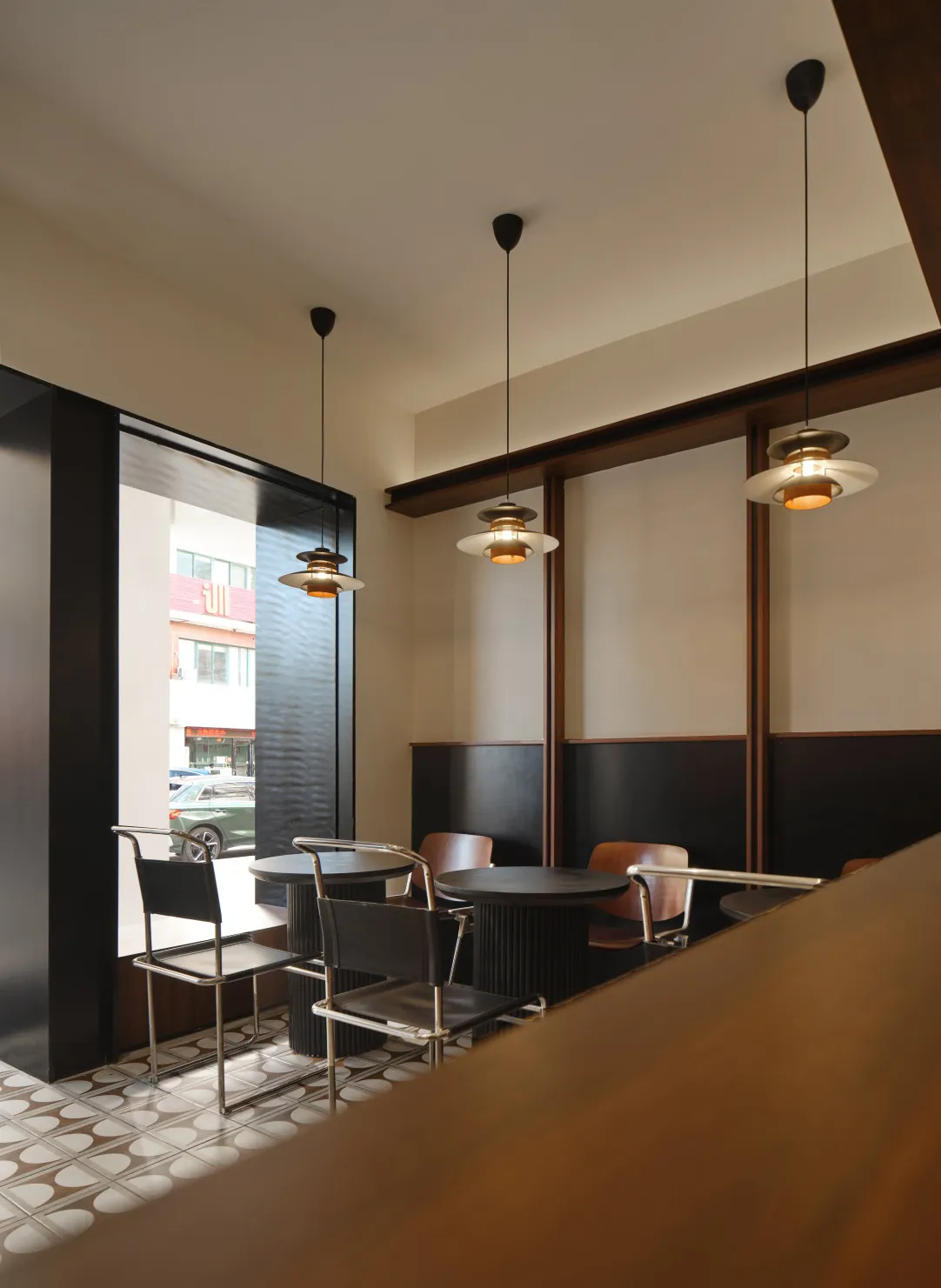 A modern restaurant interior with metallic furniture and concrete walls.