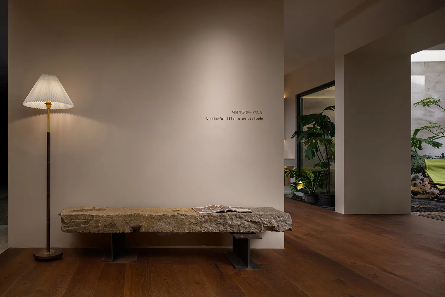 A modern living room with wooden flooring and a natural stone seating area.