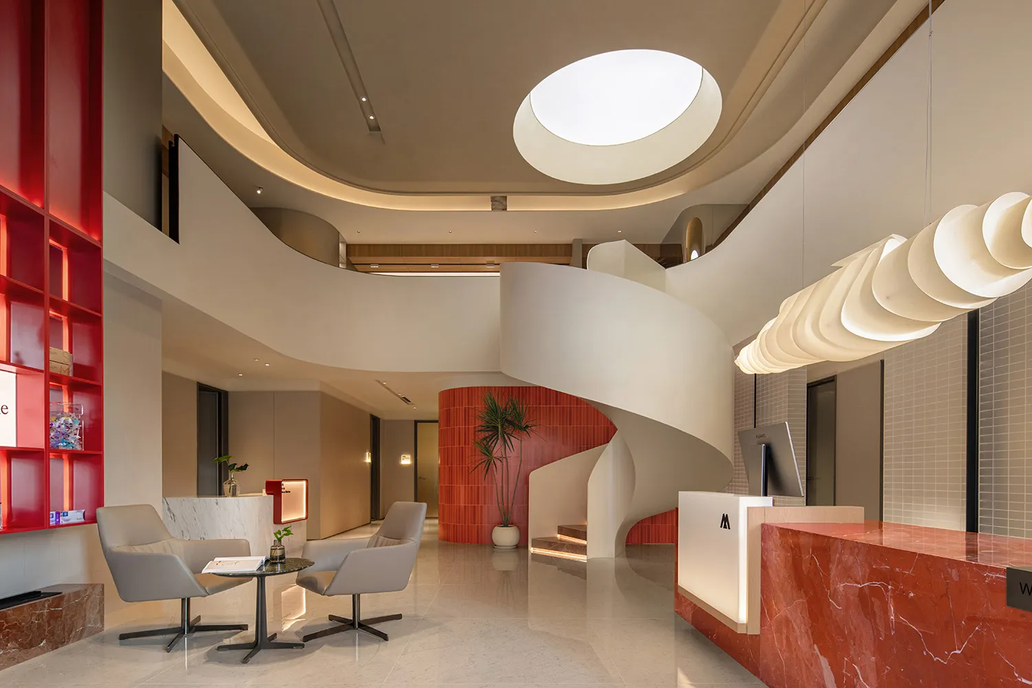 Modern office lobby interior with red marble counter, white marble chairs, concrete elements, and ambient lighting.