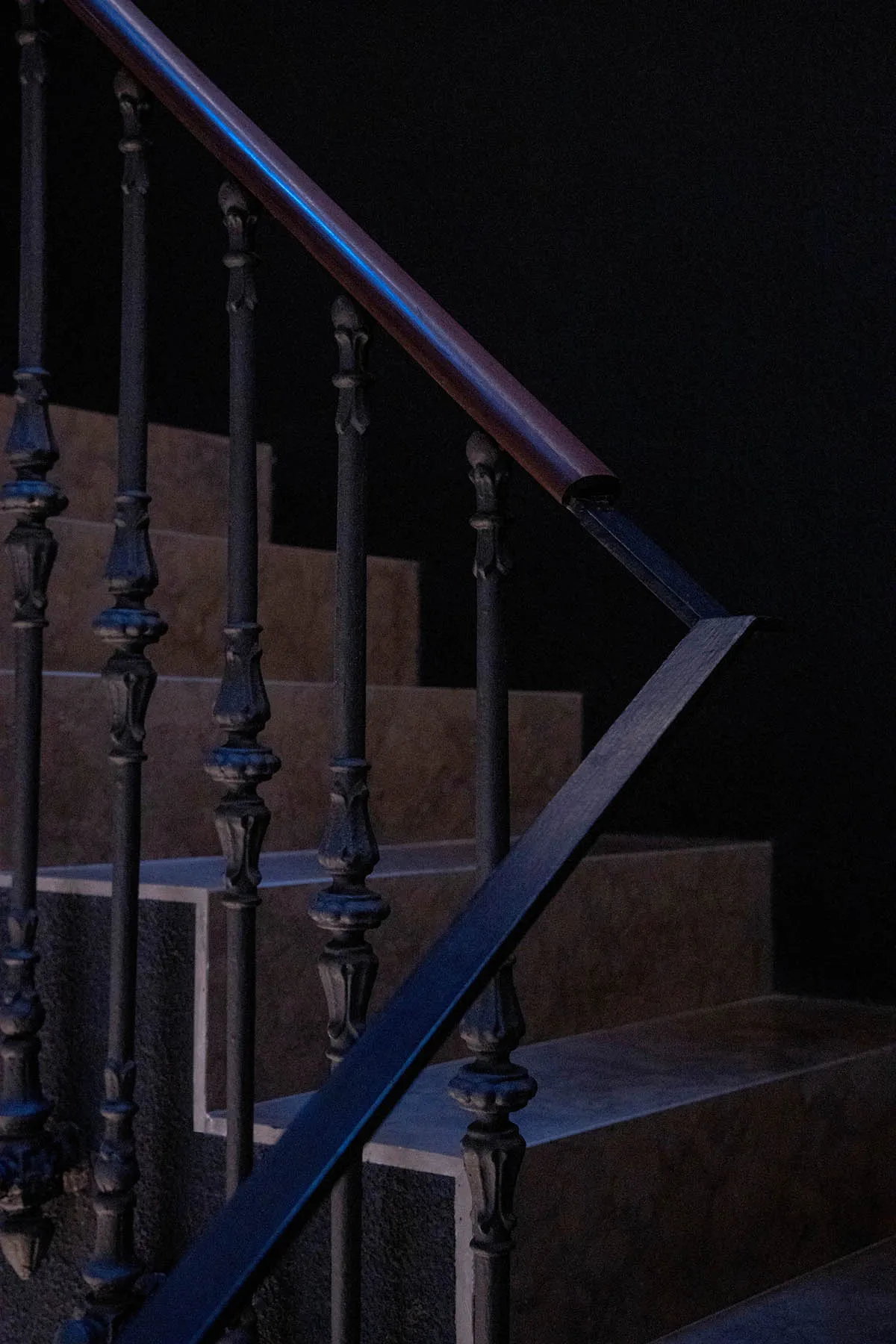 Industrial style staircase with black metal railings and wood steps.