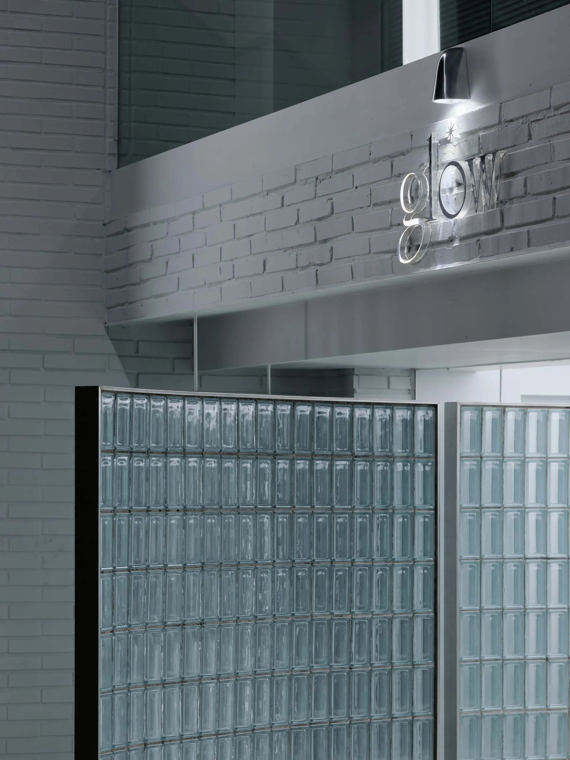 Industrial marketing office interior with glass block walls, brick accents, and concrete finishes.