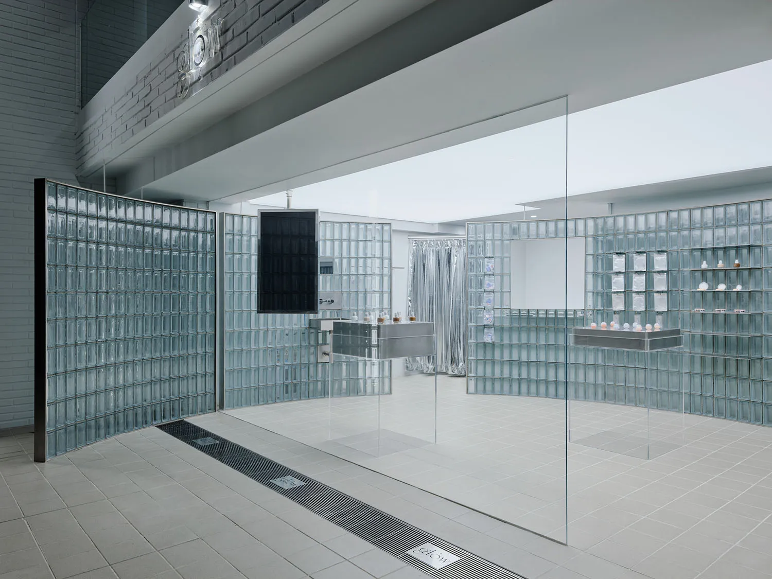 A modern retail display with walls made of translucent glass blocks, creating a minimalist and open space.