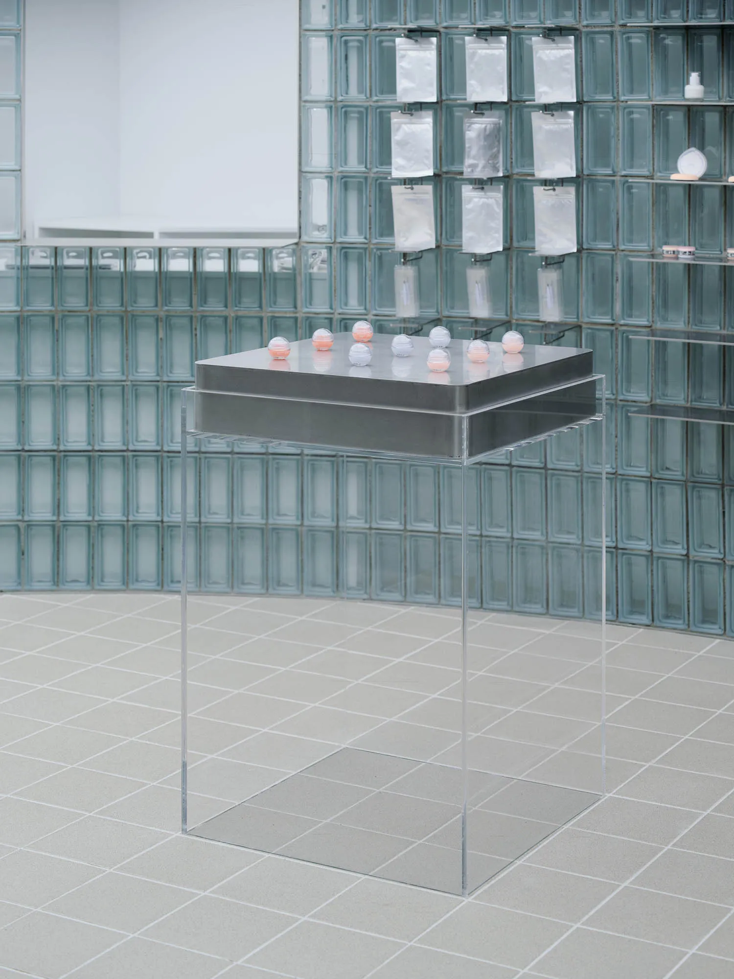Transparent glass cubes arranged on a metallic base in a modern installation setting.