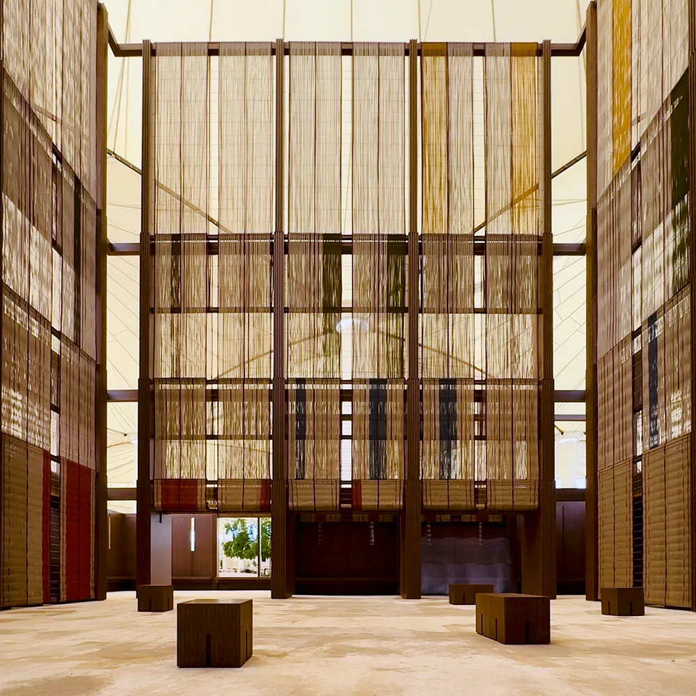 A spacious, modern atrium with textured cloth walls, designed for natural light and open space.