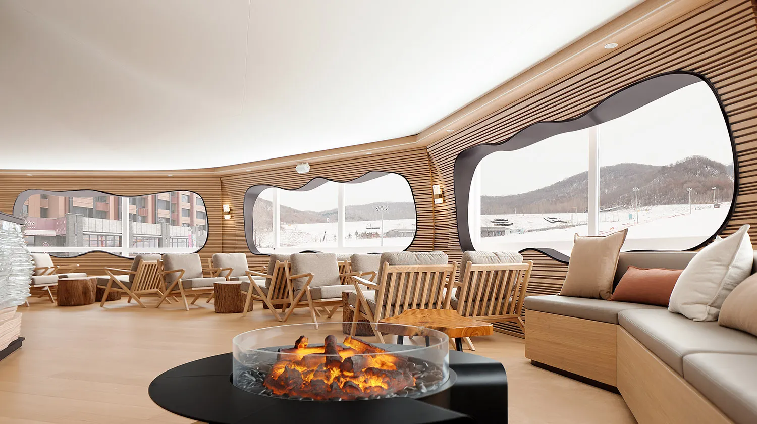 A modern lounge interior featuring a warm and inviting atmosphere with a wood-paneled room, cozy seating, and a central fire
