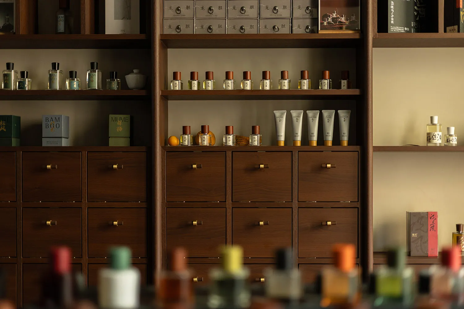 A traditional wooden cabinet displaying various bottles of perfume.