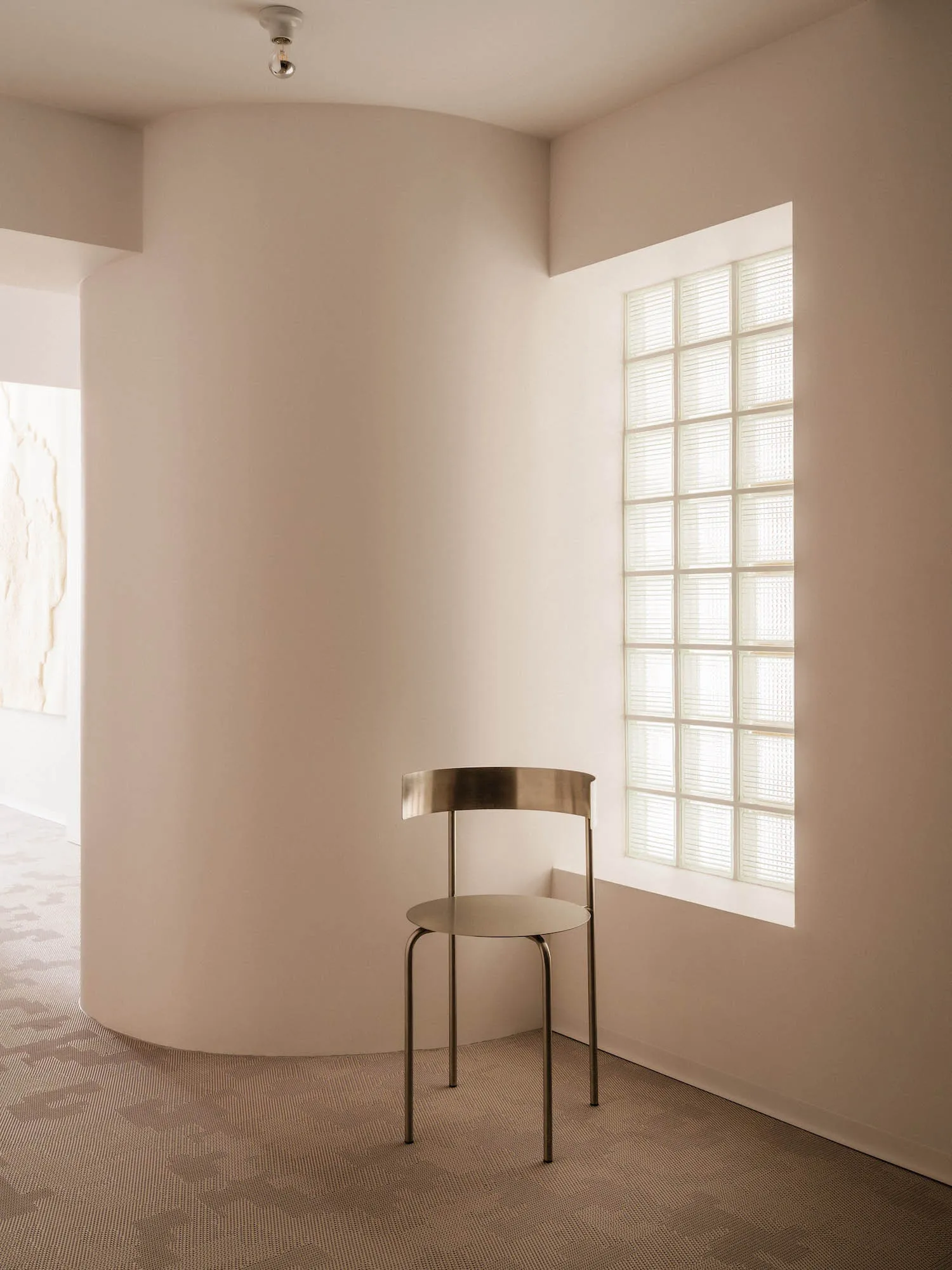 A minimalist metal chair in a modern interior design setting.