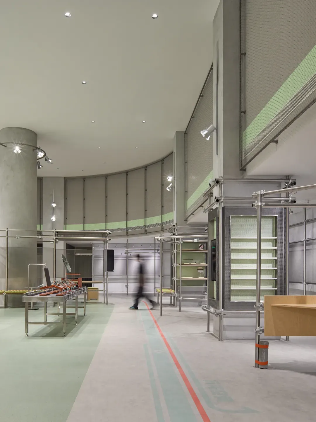 A modern retail store interior with metal fixtures, glass displays, and concrete flooring.