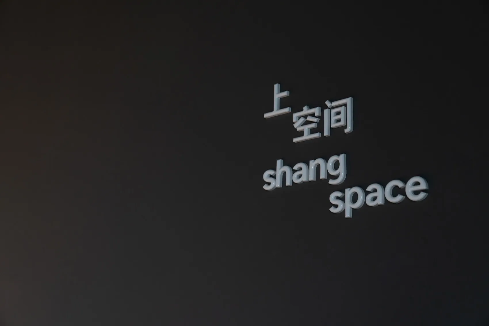A minimalist space with the words 'space' and 'shang space' written on a black wall.