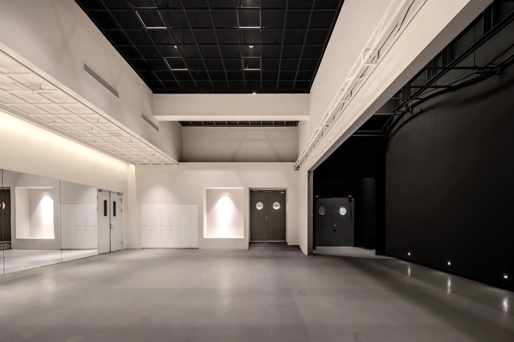 A minimalist event space with a concrete floor and industrial-style decor.