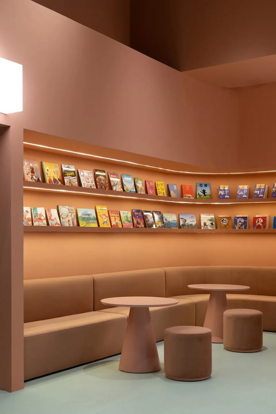 A modern interior design featuring a library cafe with terrazzo tiles and comfortable seating.