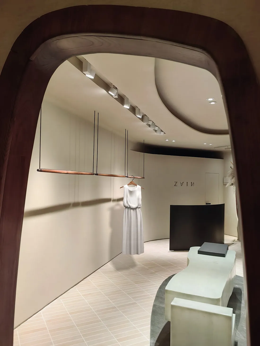 A minimalist retail store interior with wood accents, concrete walls, and glass elements.